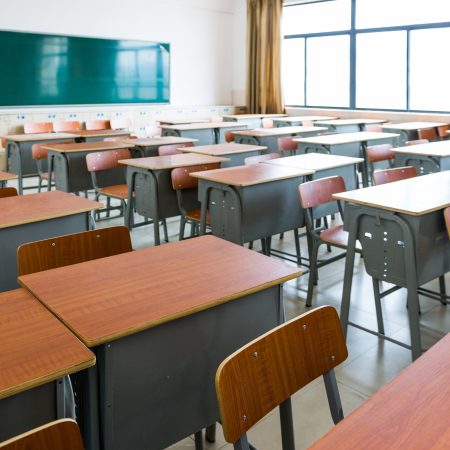 Empty classroom with desks, chairs and chalkboard